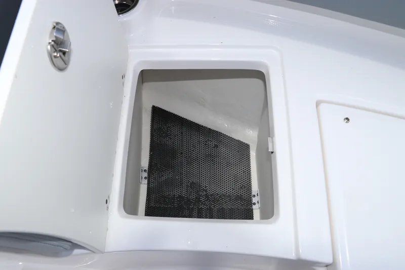 Slide: The Image of Storage compartment in 2027 Robalo R207 Dual Console boat, featuring a secure latch and interior lining. - 35