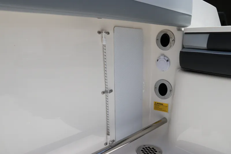 Slide: The Image of Interior view of 2027 Robalo R207 Dual Console boat, featuring utility panel and drainage system. - 17