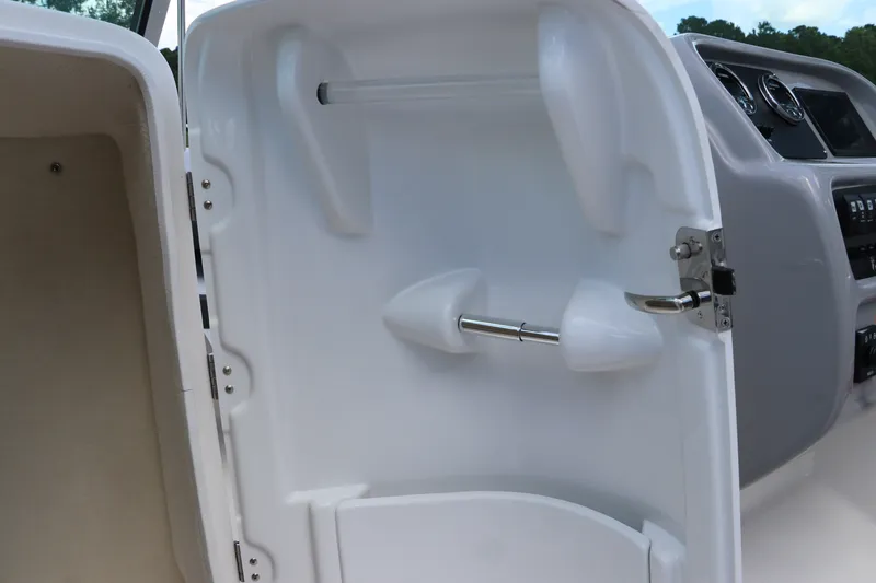 Slide: The Image of 2027 Robalo R207 Dual Console boat interior storage compartment with latch. - 24