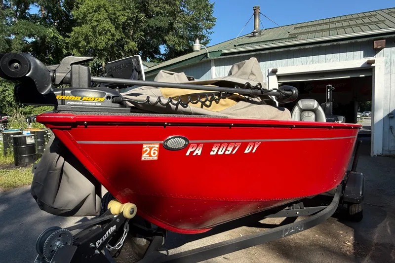 Slide: The Image of Red 2020 Lund 1675 Adventure SS boat with Minn Kota motor, parked outside a garage. - 5