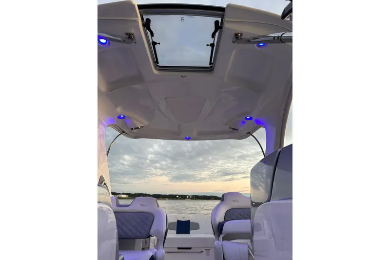 Slide: The Image of Interior view of 2013 Chaparral 327 SSX boat with blue LED lights and lake backdrop. - 26