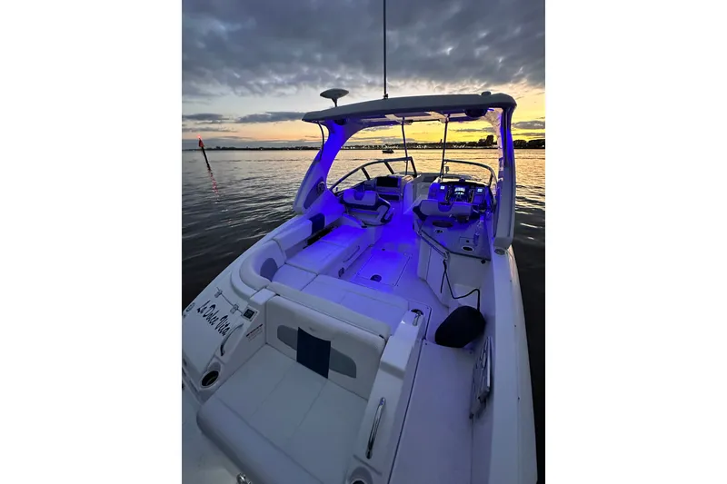 Slide: The Image of 2013 Chaparral 327 SSX boat with blue interior lights at sunset on the water. - 30
