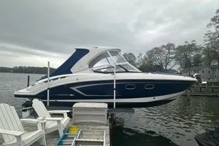 Slide: The Image of 2013 Chaparral 327 SSX boat docked by a lakeside under cloudy skies. - 4