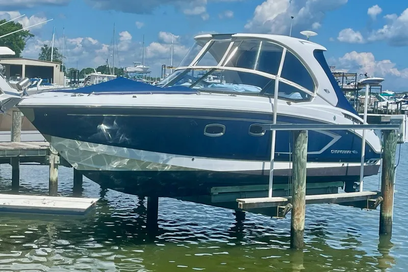 Slide: The Image of 2013 Chaparral 327 SSX boat docked at marina under clear blue sky. - 1