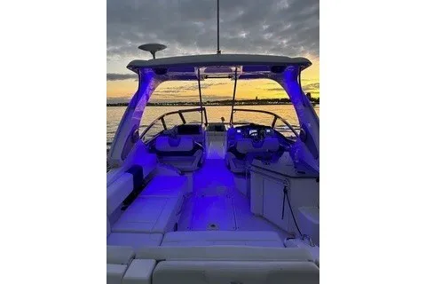 Slide: The Image of 2013 Chaparral 327 SSX boat interior with blue LED lighting at sunset. - 8