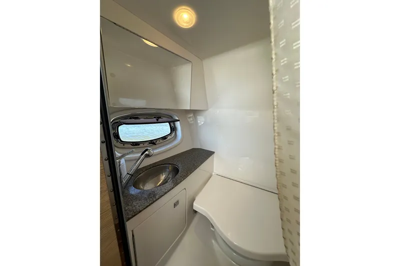 Slide: The Image of 2013 Chaparral 327 SSX boat bathroom with sink and window. - 44