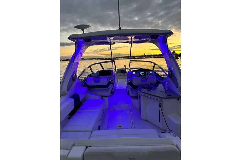 Slide: The Image of 2013 Chaparral 327 SSX boat interior with blue lighting at sunset on the water. - 31