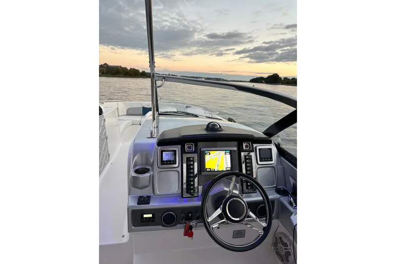 Slide: The Image of 2013 Chaparral 327 SSX boat dashboard with navigation system at sunset on the water. - 22