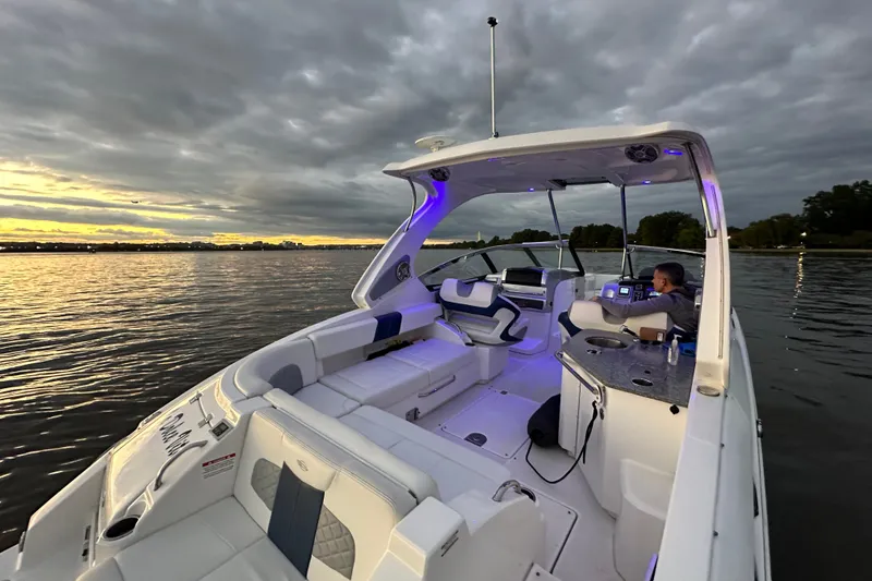Slide: The Image of 2013 Chaparral 327 SSX boat on calm water at sunset, featuring illuminated interior. - 27