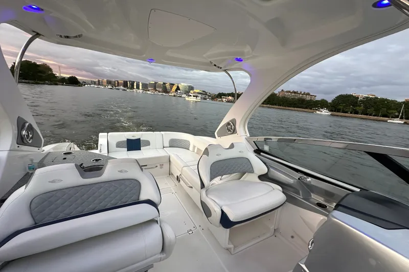 Slide: The Image of 2013 Chaparral 327 SSX boat interior with luxurious seating on a scenic waterway. - 21