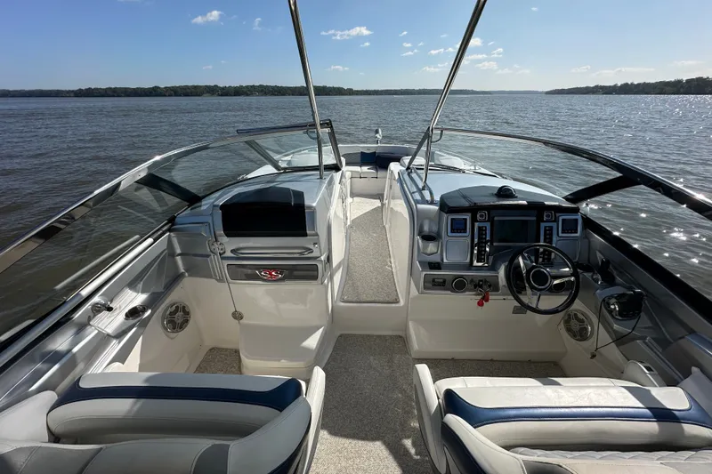 Slide: The Image of 2013 Chaparral 327 SSX boat interior with steering wheel, dashboard, and lake view. - 37