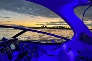 Slide: The Image of 2013 Chaparral 327 SSX boat interior with blue lighting at sunset on the water. - 9