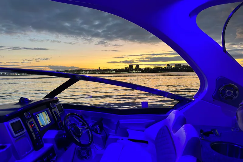 Slide: The Image of Interior view of 2013 Chaparral 327 SSX boat at sunset, featuring illuminated dashboard. - 32