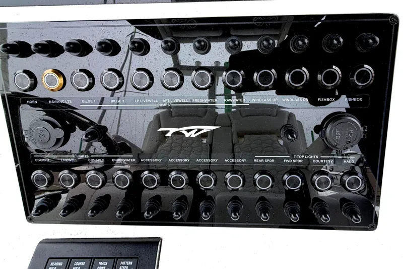 Slide: The Image of Control panel of 2026 Tidewater 320 CC Adventure boat with various switches and labels. - 20