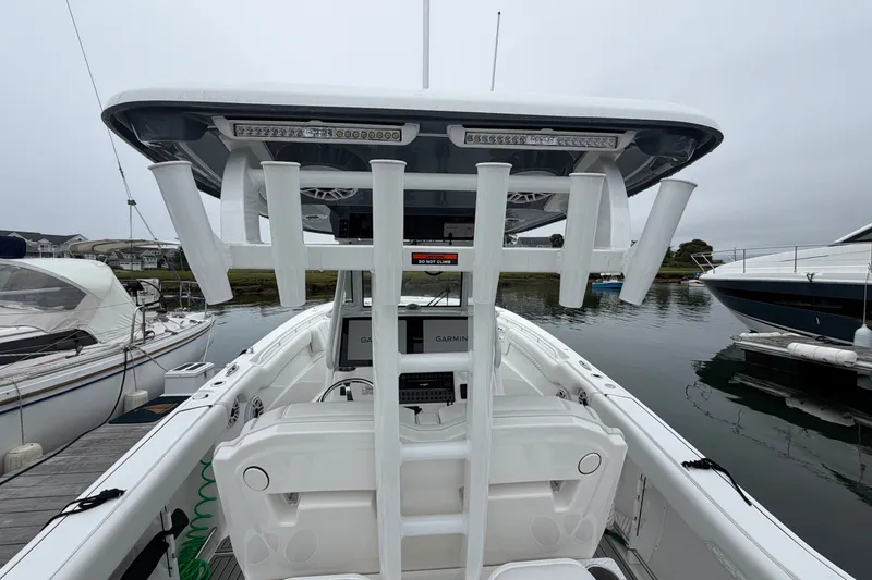 Slide: The Image of 2026 Tidewater 320 CC Adventure boat docked, featuring rod holders and advanced navigation equipment. - 63