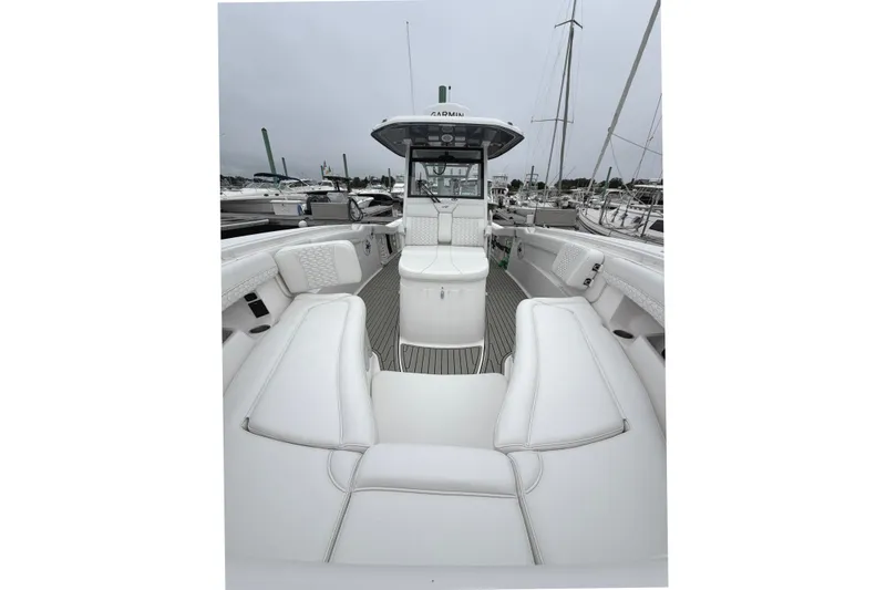 Slide: The Image of 2026 Tidewater 320 CC Adventure boat interior with white seating and helm station. - 67