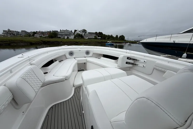Slide: The Image of 2026 Tidewater 320 CC Adventure boat interior with luxurious white seating and scenic waterfront view. - 14