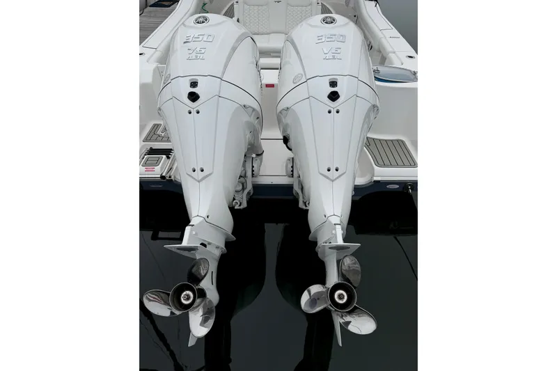 Slide: The Image of Twin outboard engines on a 2026 Tidewater 320 CC Adventure boat, docked on calm water. - 45