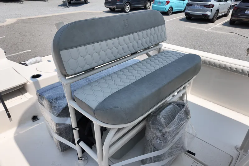Slide: The Image of 2027 Carolina Skiff 21LS boat seating with gray upholstery in a parking lot setting. - 8