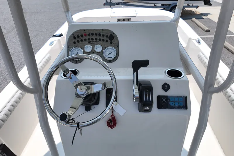 Slide: The Image of 2027 Carolina Skiff 21LS boat console with steering wheel, gauges, and controls. - 10