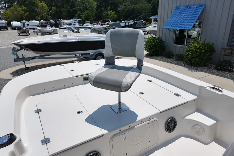 Slide: The Image of 2027 Carolina Skiff 21LS boat with a swivel seat on deck, parked outdoors. - 22