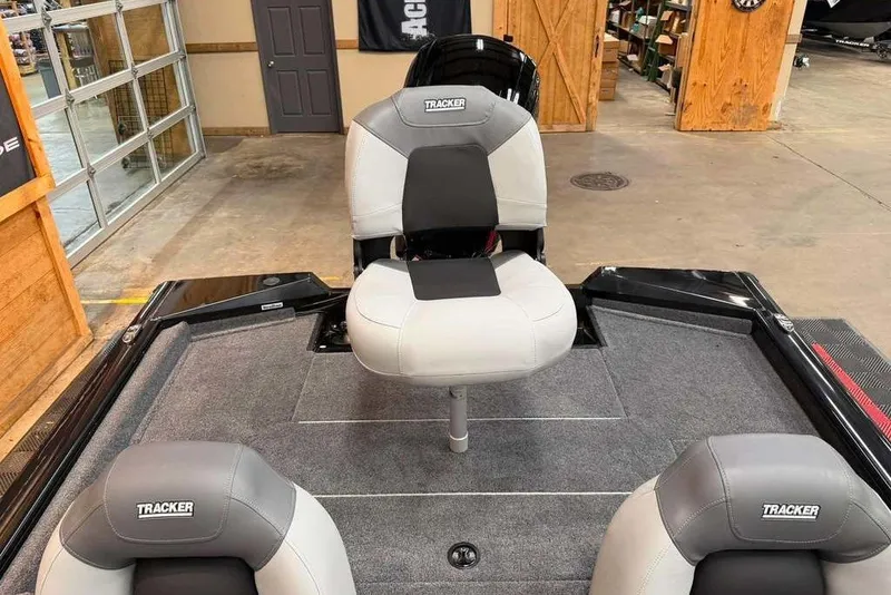 Slide: The Image of 2027 Tracker Pro Team 175 boat interior with cushioned seating in a showroom. - 8