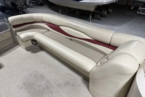 Slide: The Image of 2004 Bennington 2575 boat interior with beige and red seating in a storage area. - 8