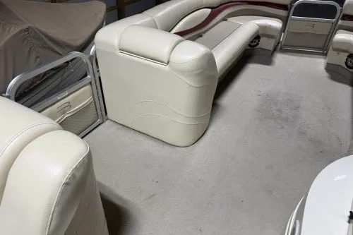 Slide: The Image of 2004 Bennington 2575 boat interior with cream leather seating and carpeted floor. - 11