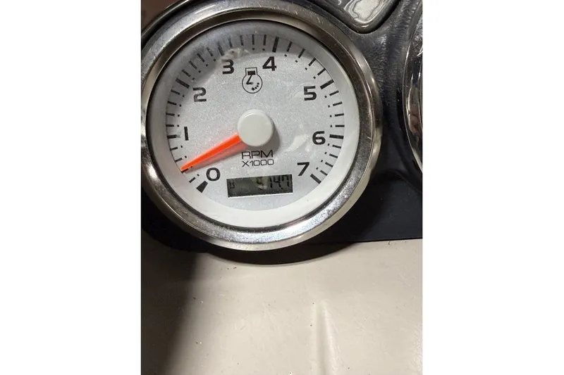 Slide: The Image of Close-up of a 2004 Bennington 2575 RPM gauge displaying 514.4 hours. - 7