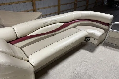 Slide: The Image of 2004 Bennington 2575 boat seating with cream and maroon upholstery in a storage area. - 10