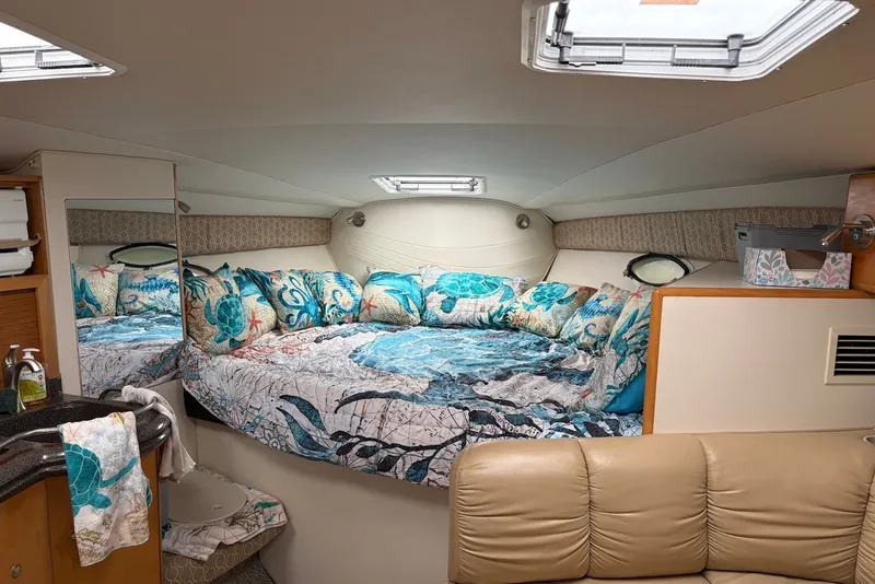 Slide: The Image of Interior of 2001 Larson Cabrio 330 boat with cozy bed and nautical-themed decor. - 13