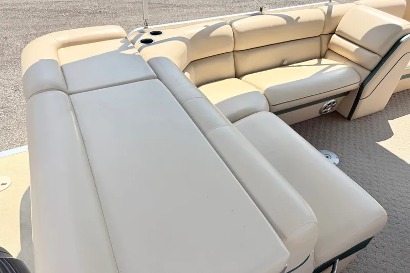 Slide: The Image of Luxurious beige seating on 2015 South Bay 520CR pontoon boat, featuring cup holders and speaker. - 12