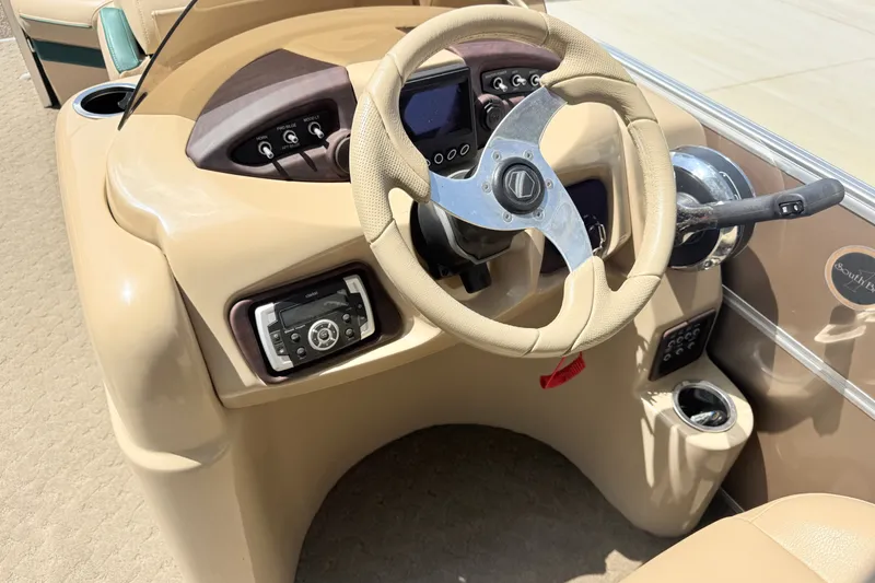 Slide: The Image of Steering console of a 2015 South Bay 520CR boat with beige interior. - 9