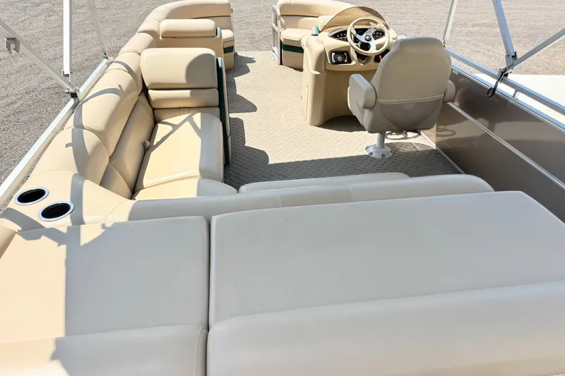 Slide: The Image of 2015 South Bay 520CR pontoon boat interior with beige seating and steering console. - 3
