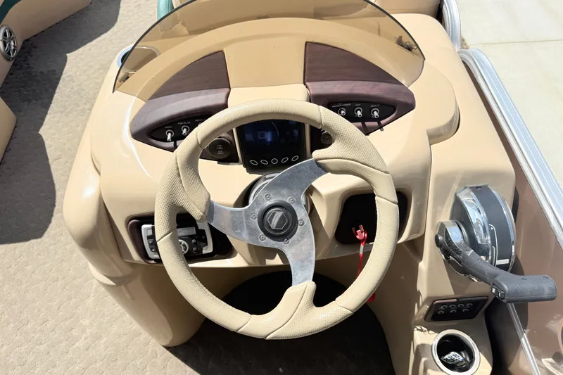 Slide: The Image of Steering console of a 2015 South Bay 520CR boat with beige dashboard and controls. - 10