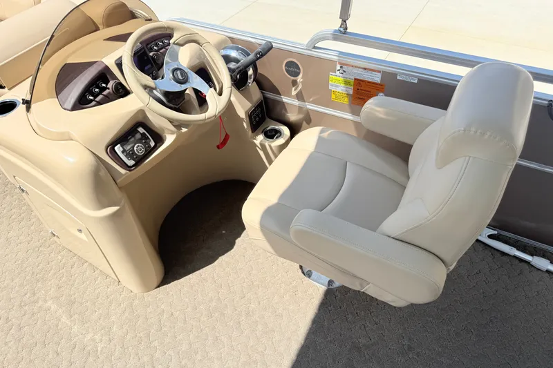 Slide: The Image of Captain's seat and helm of 2015 South Bay 520CR pontoon boat, featuring beige upholstery. - 7