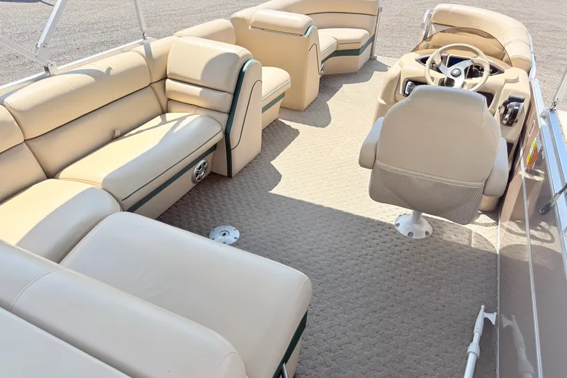 Slide: The Image of 2015 South Bay 520CR pontoon boat interior with beige seating and steering console. - 4