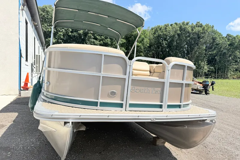 Slide: The Image of 2015 South Bay 520CR pontoon boat with canopy, parked outdoors on a sunny day. - 2
