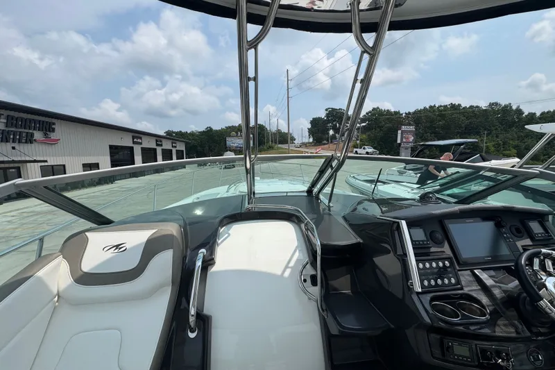 Slide: The Image of 2018 Monterey 355 Sport Yacht cockpit with modern controls and seating, under a partly cloudy sky. - 10