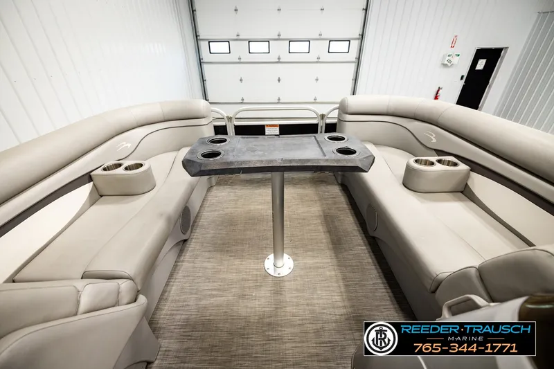 Slide: The Image of 2021 Bennington SVSR boat interior with beige seating and central table in showroom. - 18