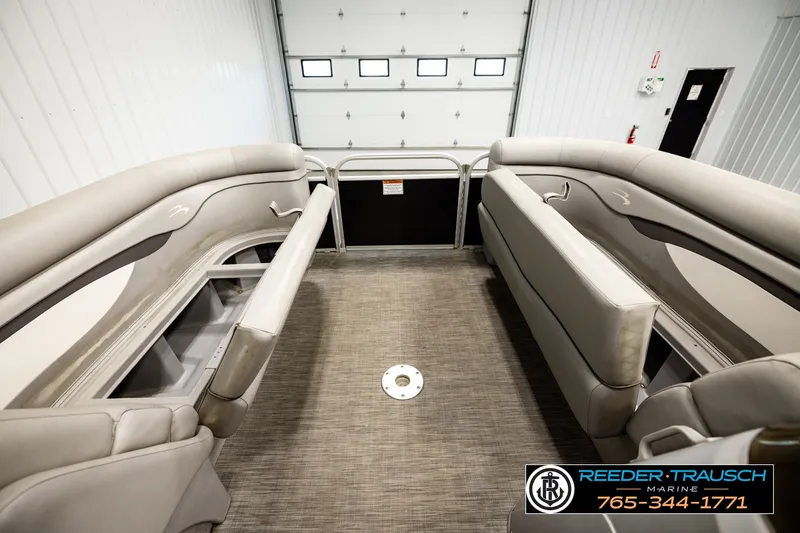 Slide: The Image of 2021 Bennington SVSR boat interior with beige seating, displayed in a showroom. - 21