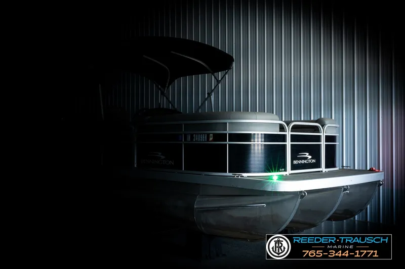 Slide: The Image of 2021 Bennington SVSR pontoon boat in dimly lit storage, Reeder-Trausch Marine contact displayed. - 4