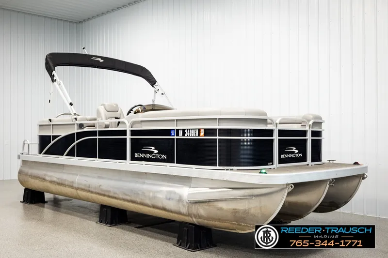 Slide: The Image of 2021 Bennington SVSR pontoon boat displayed indoors at Reeder-Trausch Marine showroom. - 2