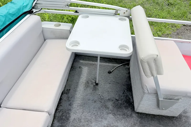 Slide: The Image of Interior of a 1993 Crest Sport boat with seating and a table. - 7