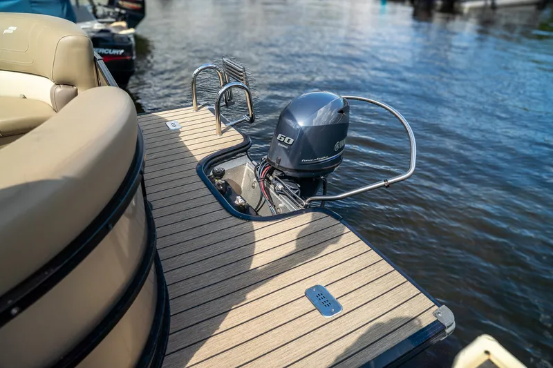 Slide: The Image of The image shows the stern of a 2021 Starcraft CX 21 R with an outboard motor on calm water. - 5