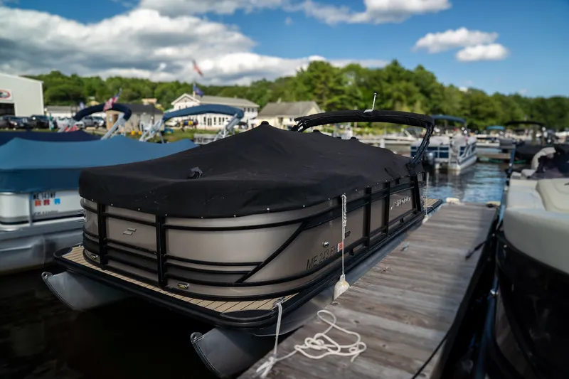 Slide: The Image of A 2021 Starcraft CX 21 R pontoon boat docked, covered with a black tarp. - 12