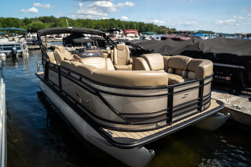 Slide: The Image of A sleek pontoon boat with beige seating and black railing, floating on the water. - 4