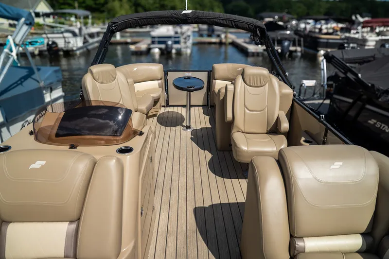Slide: The Image of The image shows the deck of a 2021 Starcraft CX 21 R with beige leather seating. - 8