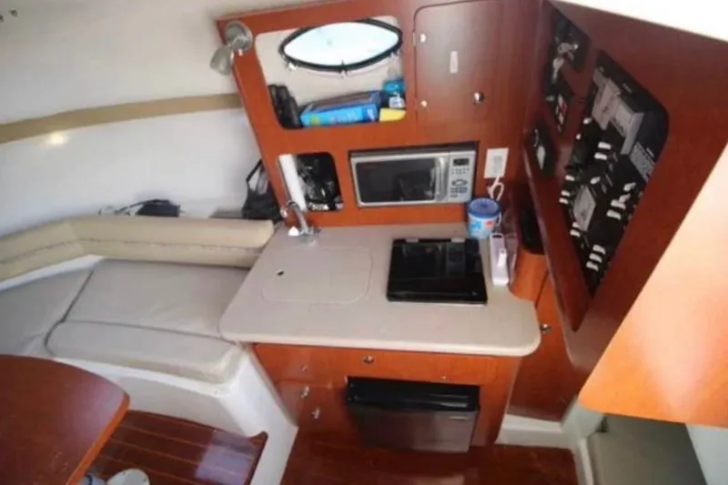 Slide: The Image of 2006 Pro-Line 32 Express cabin interior with kitchenette, featuring microwave and seating area. - 8