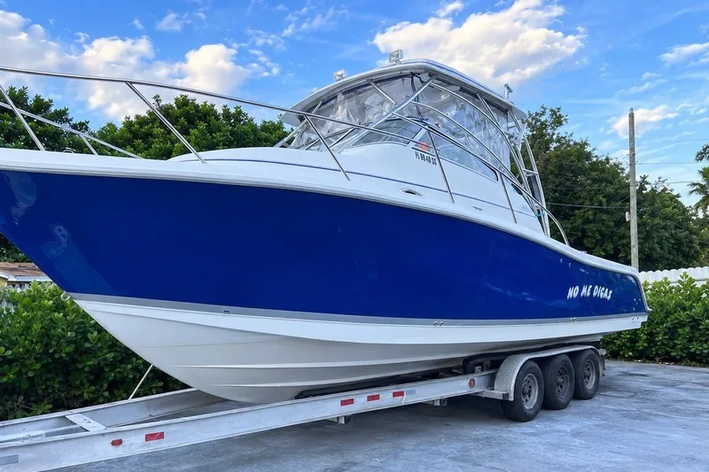 The Image of A 2006 Pro-Line 32 Express boat on a trailer, featuring a blue hull and white superstructure. - 0